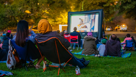 Couple in low chairs watches a movie in a Berkeley park