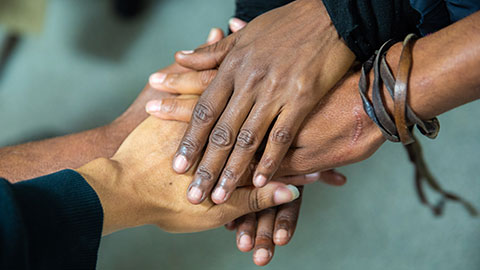 Stacked hands of various skin tones