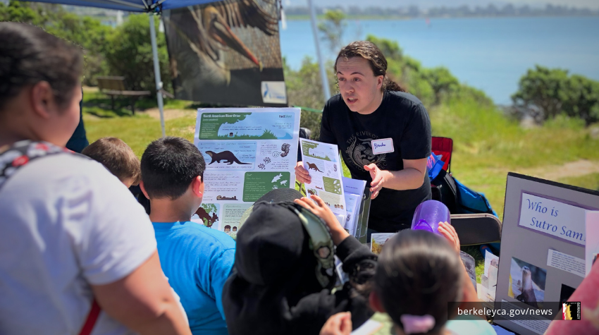 Person talks about conservation at a booth at the Berkeley Bay Festival. 