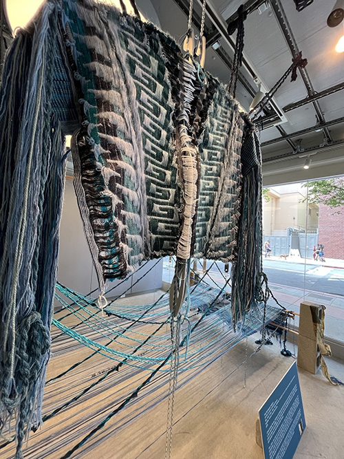 Blue yarn art wrapped in looms that looks like a bridge