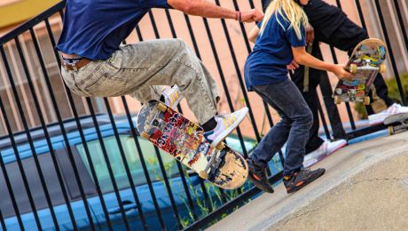 people perform skateboard tricks flipping a colorful board over in the air