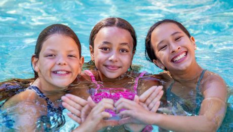 Three smiling girls in swimming pool
