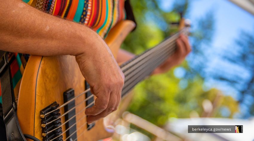Person strum guitar at outdoor venue