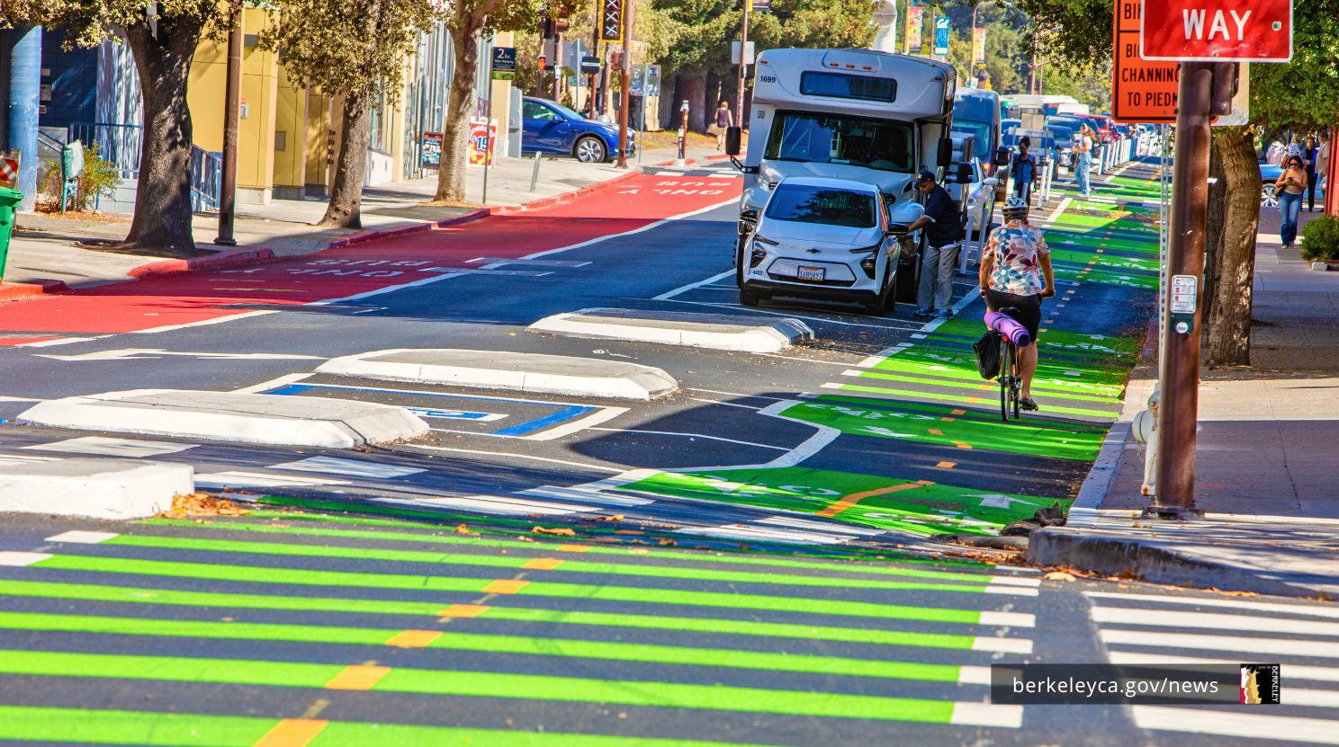 A bicyclist bikes uphill on the protected bike lane on Bancroft Way