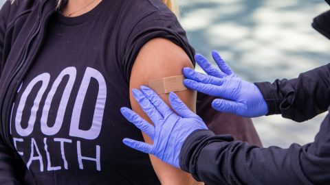 Applying a bandage to an arm with gloved hands