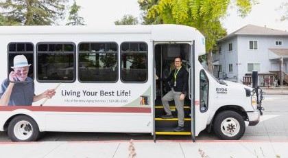 Large passenger van with a staff member standing in entry stairs