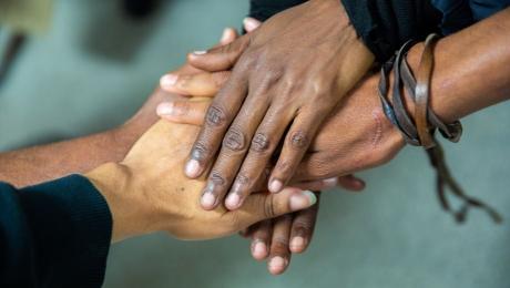Hands of various skin tones stacked together