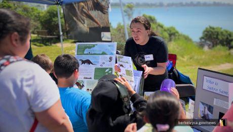 Person talks about conservation at a booth at the Berkeley Bay Festival. 