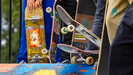 Three colorful skateboards in yellow, red, green, blue at a skate park