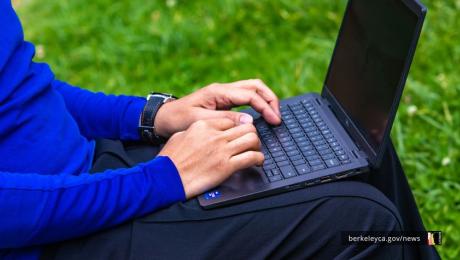 Person typing on a laptop outdoors