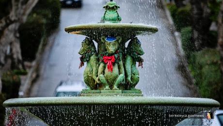 Flowing water fountain with bear sculptures in wearing red ribbon