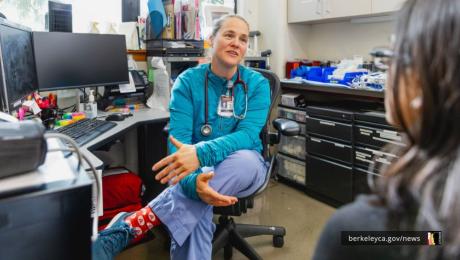 Woman wearing a stethoscope talking to a patient