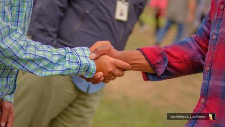 Two hands shaking at a City of Berkeley event