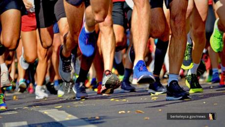 A close-up view of runners' legs and shoes in motion during a road race, with colorful sneakers on the street.