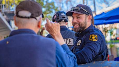 Resident talks with smiling police officer.