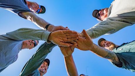 Group of people stacking hands in a circle
