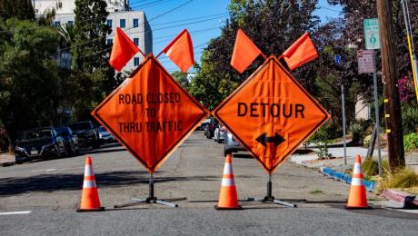 two temporary construction detour warning signs