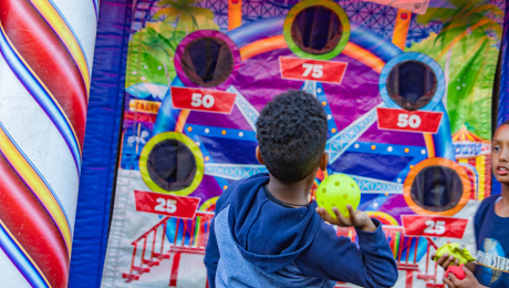 Kid throws a ball at a carnival game