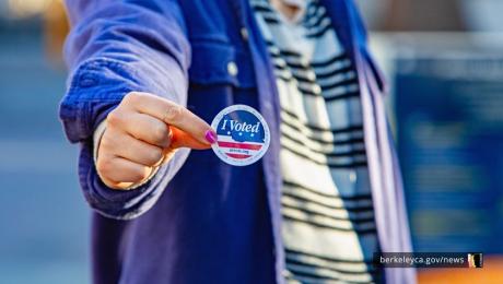 Person holds up an "I voted" sticker