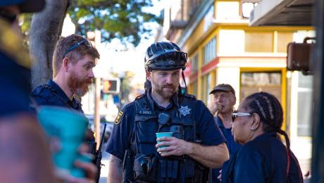 Two police officers in conversation with a woman