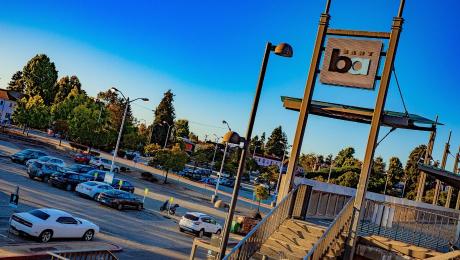 Outside parking lot with parked vehicles and a BART sign. 
