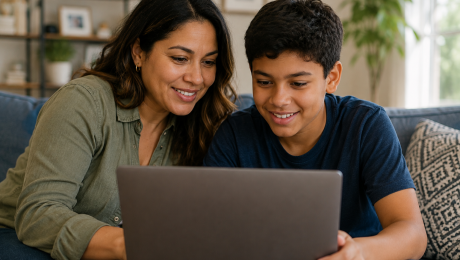 Parent and their young teenager looking at laptop