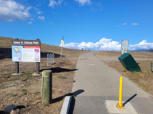 Paved pathway with sign for Cesar Chavez park