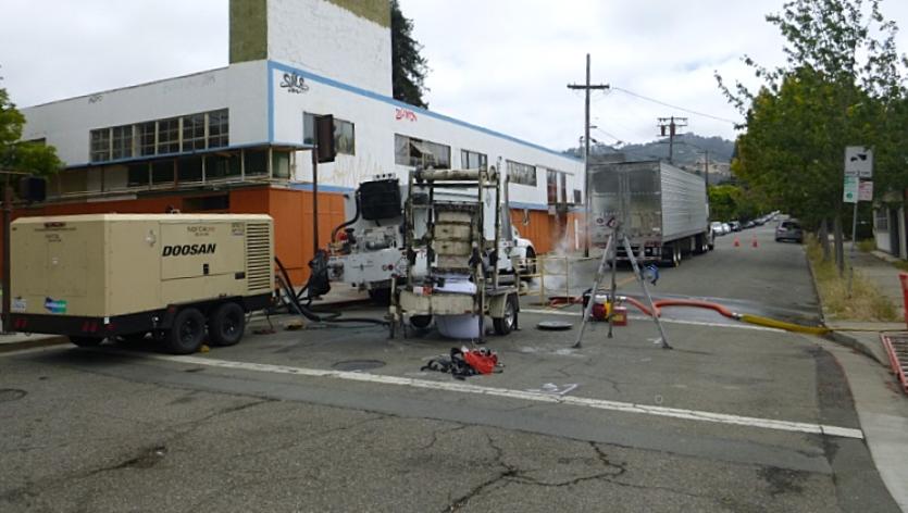 Steam rising from a maintenance hole at a construction site