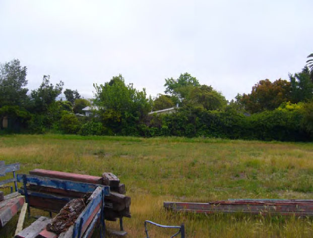 Vacant lot on Allston Way with weathered debris.